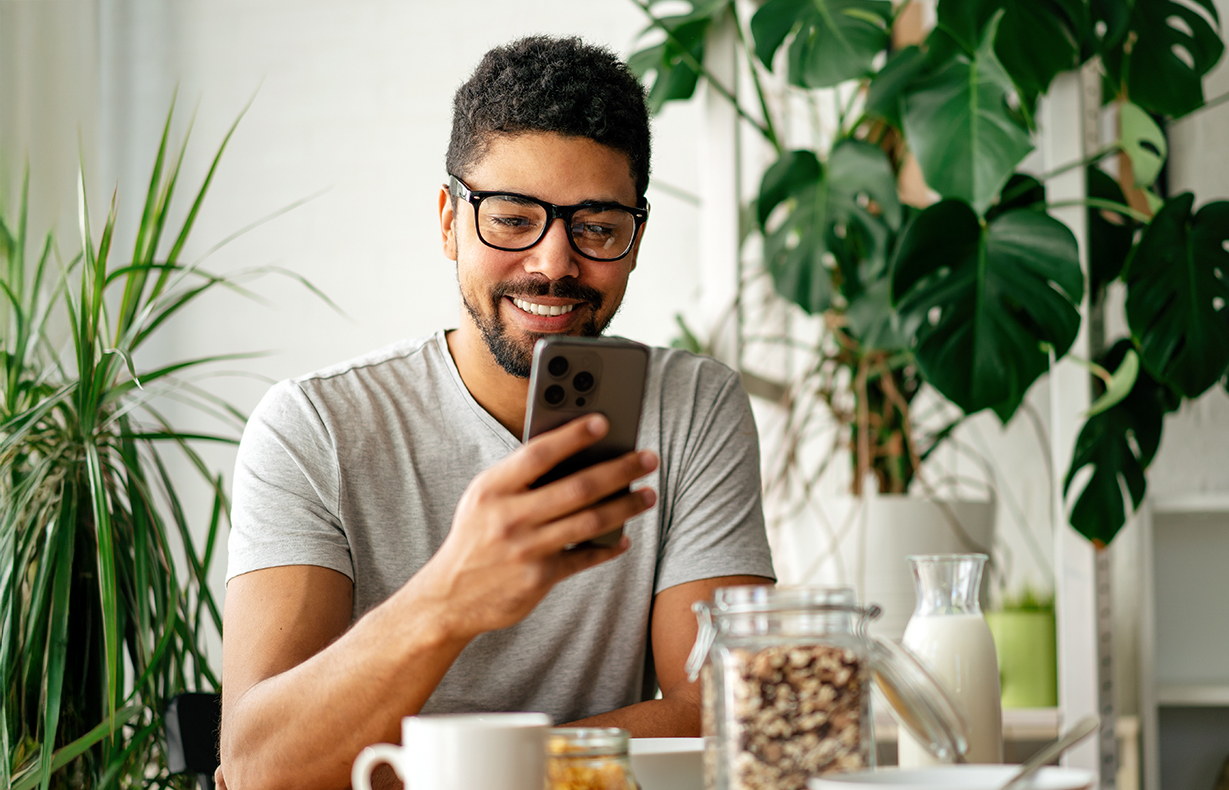 Adult looking at phone, smiling.